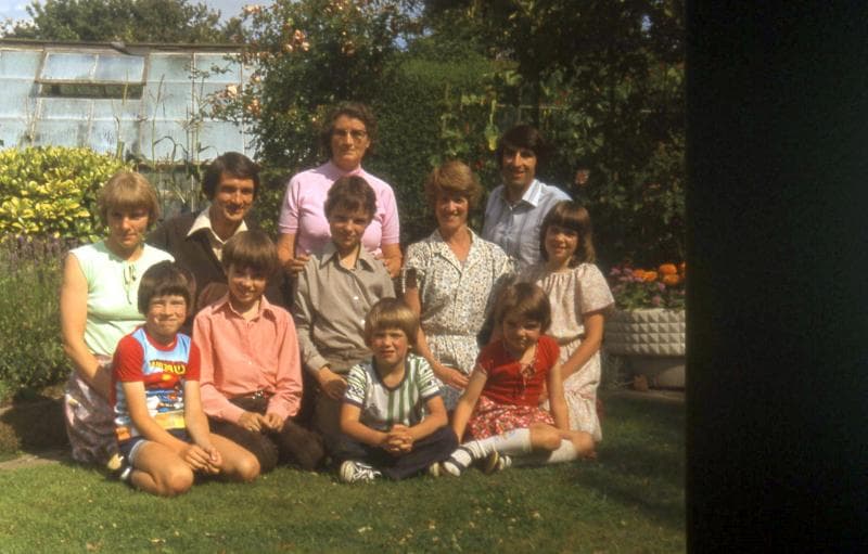 Family photo, David's Mum and Dad's garden (Back row: L to R - Karen, Howard, David's Mum Enid, David. Front row: Marc, Gareth, Dafydd, Heather, Sian with Ceri and Mairwen in front.